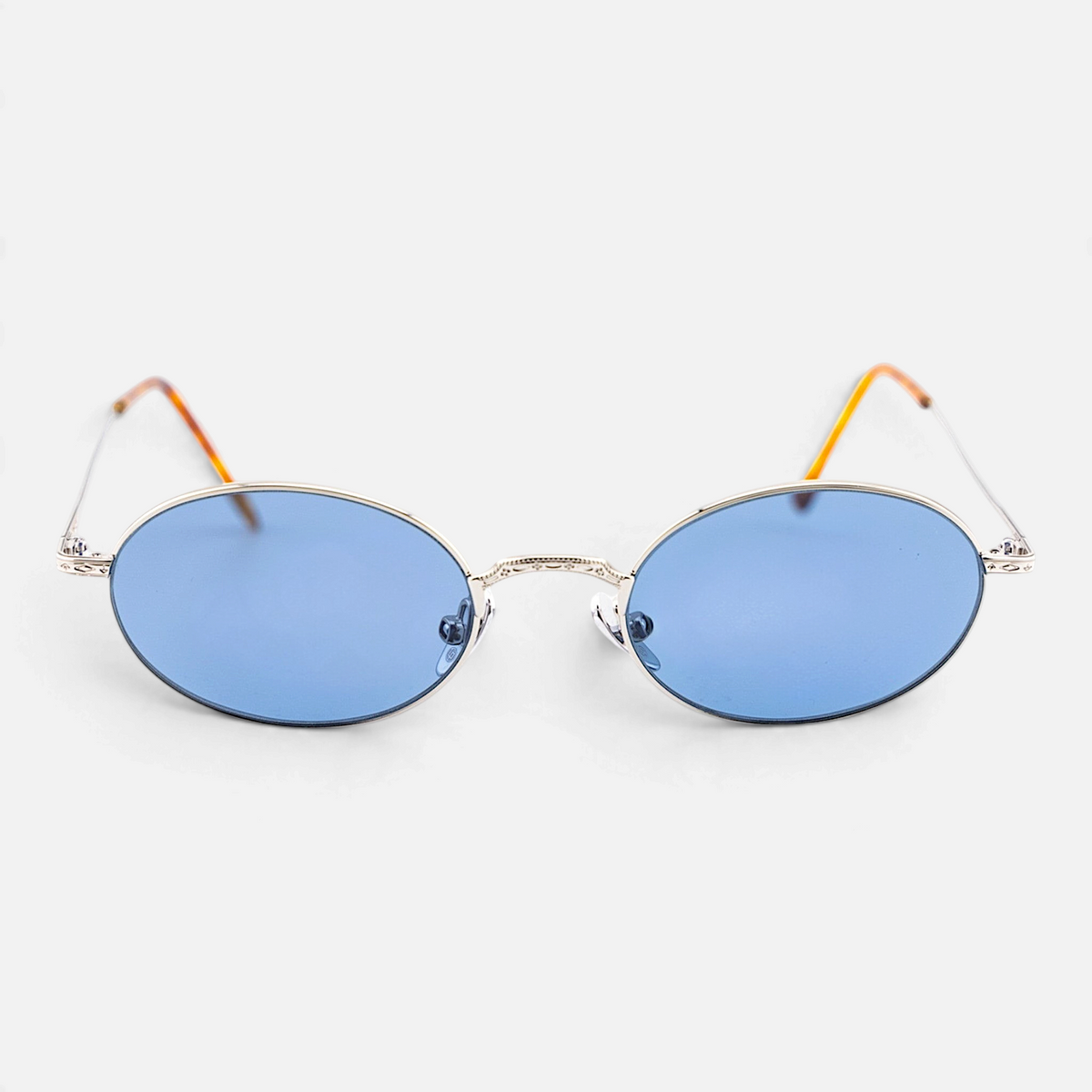 Occhiali Bottega di Sguardi Catalina II con montatura ovale in metallo argento e lenti azzurre, stile vintage.